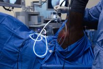 Partie médiane d'une chirurgienne examinant un cheval en salle d'opération — Photo de stock