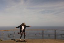 Skateboarder femme patinant sur le point d'observation — Photo de stock