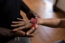 Крупним планом чоловічий тренер, що допомагає жінці-боксерові в обгортанні рук у фітнес-студії — стокове фото