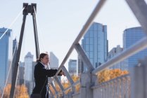 Продуманий чоловік стоїть на мосту в місті — стокове фото