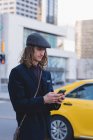 Uomo che usa il telefono cellulare mentre cammina per strada in città — Foto stock
