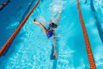Jovem nadadora do sexo feminino nadando estilo livre na piscina — Fotografia de Stock