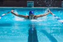 Vista frontale del giovane nuotatore femminile con maschera nuoto nuoto in piscina — Foto stock
