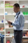 Вид збоку молодого азіатського лікаря, який тримає медицину і стоїть в клініці — стокове фото