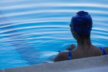 Rückenansicht einer Schwimmerin, die sich im Schwimmbad entspannt — Stockfoto