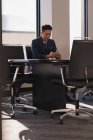 Вид збоку бізнесмена сидячи за допомогою мобільного телефону в конференц-залі, в офісі — стокове фото