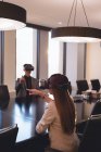 Visão traseira de pessoas de negócios usando fone de ouvido VR na sala de conferências no escritório — Fotografia de Stock