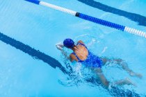 Vista de ángulo alto de nadadora femenina nadando braza en piscina - foto de stock