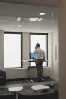 Бізнесмен розмовляє на мобільному телефоні під час тренувань на біговій доріжці в офісі — стокове фото