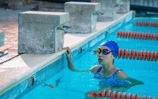 Vista frontal de una nadadora tensa esperando los resultados en la piscina - foto de stock