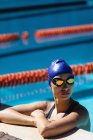 Vista lateral da jovem nadadora em pé na piscina — Fotografia de Stock