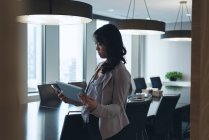 Вид збоку бізнес-леді за допомогою цифрових таблиці в конференц-залі, в офісі — стокове фото