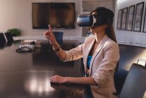 Side view of businesswoman using VR headset in the conference room at office — Stock Photo