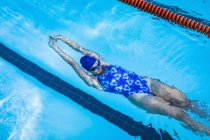 Vista de ángulo alto de la espalda nadadora femenina en la piscina - foto de stock