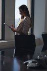Вид збоку на стоячу бізнес-леді, використовуючи цифровий стіл у конференц-залі в офісі — стокове фото