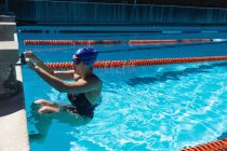 Vista lateral de uma jovem nadadora nadadora na piscina — Fotografia de Stock
