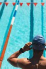 Vista de alto ângulo do jovem nadador masculino usando óculos de natação na piscina no dia ensolarado — Fotografia de Stock