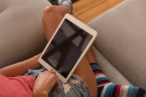Visão de alto ângulo da mulher usando tablet digital na sala de estar em casa — Fotografia de Stock