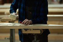 Sección media del carpintero usando cincel con martillo en taller - foto de stock