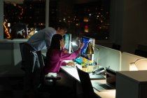 Vista laterale di giovani dirigenti di uffici multietnici che lavorano su PC desktop alla scrivania in un ufficio moderno — Foto stock