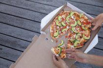 Ângulo de visão alta de amigos desfrutando de festa de pizza — Fotografia de Stock