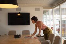 Вид сбоку на азиатскую предпринимательницу, использующую цифровой планшет в офисе — стоковое фото