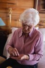 Frontansicht einer aktiven Seniorin, die zu Hause im Schlafzimmer Medikamente einnimmt — Stockfoto
