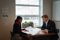Вид збоку на різноманітних бізнесменів, які обговорюють план конференц-залу в офісі — стокове фото