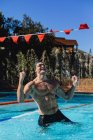 Vista frontale di un nuotatore maschio eccitato che celebra la sua vittoria in piscina — Foto stock