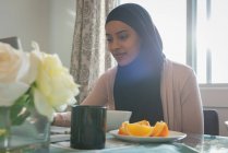 Niedrigwinkel-Ansicht der jungen gemischten Rasse schöne Frau trägt Hijab arbeiten am Laptop zu Hause — Stockfoto