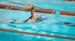 Seitenansicht junger kaukasischer Schwimmer schwimmt Freistil im Freibad an sonnigem Tag — Stockfoto