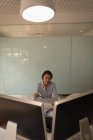 Vue de face d'une graphiste asiatique regardant des croquis dans son bureau — Photo de stock