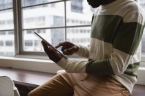 Sección media del empresario afroamericano usando tableta digital en cantina de oficina - foto de stock