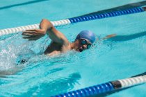 Seitenansicht junger kaukasischer Schwimmer schwimmt Freistil im Freibad in der Sonne — Stockfoto