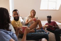 Frontansicht einer Gruppe unterschiedlicher Menschen, die zu Hause sitzen und miteinander reden — Stockfoto