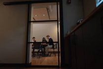 Visão de baixo ângulo de diversos empresários discutindo uns com os outros na sala de conferências no escritório — Fotografia de Stock