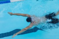 Vista de alto ângulo de um nadador masculino nadando peito debaixo d 'água na piscina — Fotografia de Stock