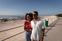 Vorderansicht eines afrikanisch-amerikanischen Paares, das am Meer spazieren geht und genießt — Stockfoto