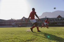 Вид сбоку на африканского регбиста, играющего в регби в солнечный день — стоковое фото