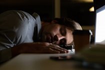 Вид збоку на молодого чоловіка виконавчого сну за столом в сучасному офісі — стокове фото