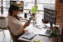 Вид збоку бізнес-леді, використовуючи цифровий планшет в офісі — стокове фото