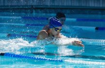 Vue latérale de jeunes nageuses nageant en freestyle brasse dans la piscine — Photo de stock