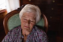 Frontansicht einer Seniorin, die zu Hause auf einem Sessel im Wohnzimmer schläft — Stockfoto