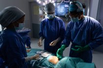 Front view of surgeons performing operation in operating room at hospital — Stock Photo