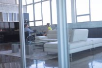 Visão traseira de deficientes maduros caucasiano masculino e branco loira executivo feminino interagindo uns com os outros no escritório — Fotografia de Stock