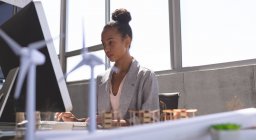 Niederwinkelaufnahme einer Geschäftsfrau mit gemischter Rasse, die am Computer am Schreibtisch im Büro arbeitet — Stockfoto