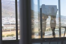 Vista posteriore di maturo maschio caucasico e bionda caucasica architetti femminili discutendo sopra cianografia in ufficio — Foto stock