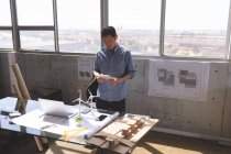 Visão de alto ângulo do jovem executivo masculino asiático usando tablet digital no escritório de arquitetura — Fotografia de Stock