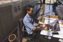 Vue en angle élevé du jeune exécutif masculin asiatique en utilisant un ordinateur portable dans le bureau d'architecture — Photo de stock