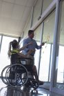Vue latérale de handicapés Blond blanc femme et homme exécutif discuter sur des notes collantes dans le bureau — Photo de stock